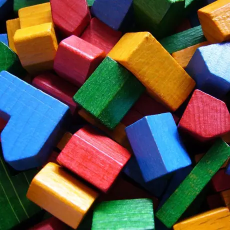 Settlements and cities, the building blocks of a player's game in Settlers of Catan. As a side note, the white and brown bits were omitted from this photo for aesthetic reasons.
