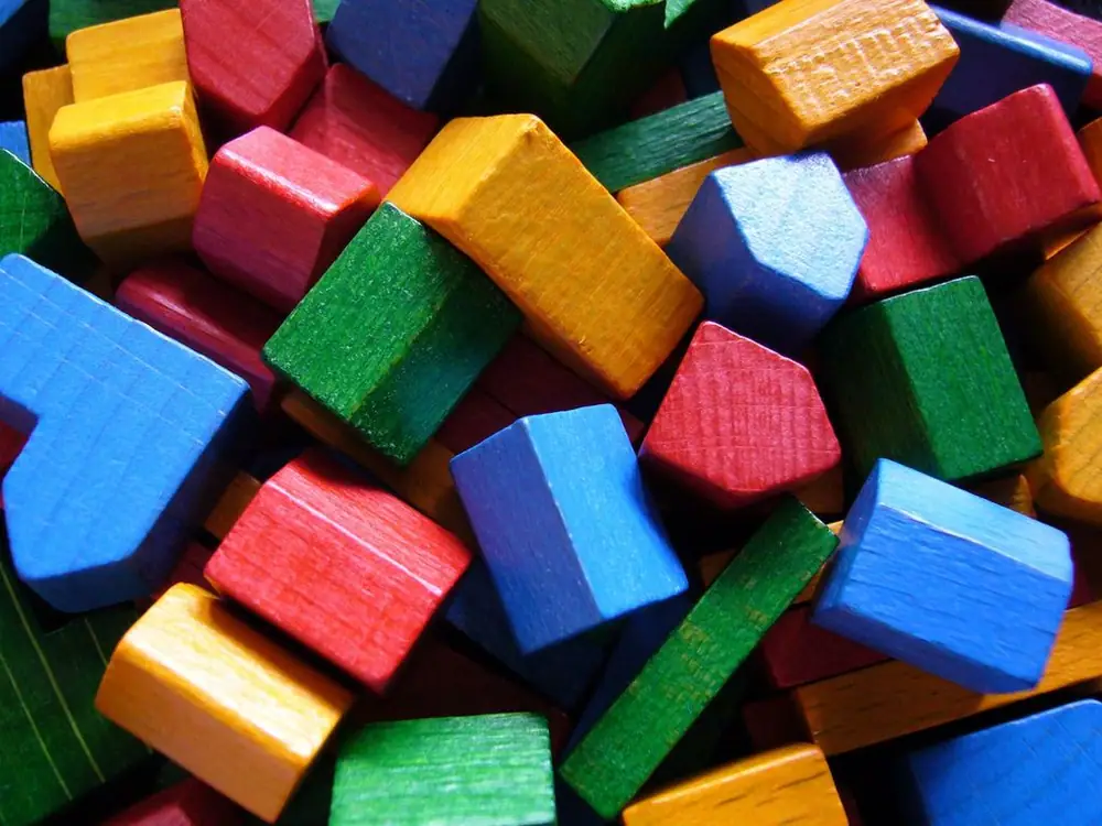 Settlements and cities, the building blocks of a player's game in Settlers of Catan. As a side note, the white and brown bits were omitted from this photo for aesthetic reasons.